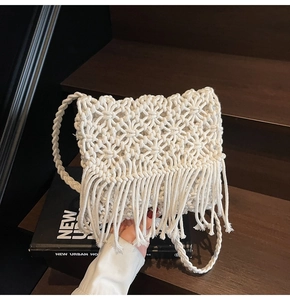 Détail de sac en paille blanc fait main avec pompons et bandoulière tressée