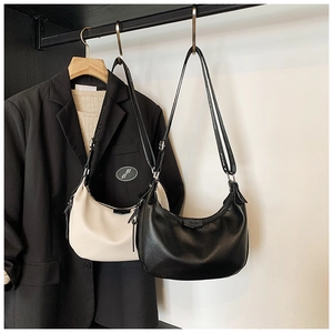 Détail du sac hobo en cuir grainé avec une bandoulière large et un design contemporain