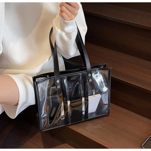 Détail d'un grand sac cabas transparent en PVC avec bordure en similicuir noir et rivets