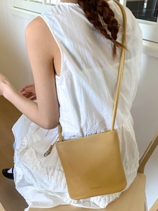Sac seau minimaliste en cuir jaune vif avec texture litchi et bandoulière réglable