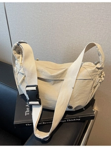 Lightweight beige nylon half-moon crossbody bag with wide adjustable shoulder strap