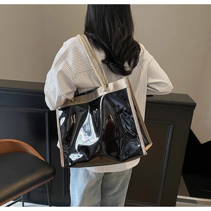 Detail of glossy black PVC tote bag with thick rope handles and contrast stitching
