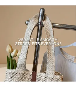 Detail of woven straw tote bag with wide shoulder strap and leather trim accents