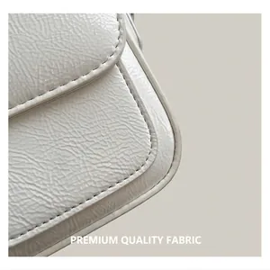 Gros plan sur la texture du cuir blanc plissé et les coutures de ce sac minimaliste