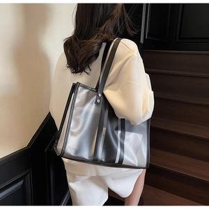 Détail du sac cabas en PVC transparent avec rayures noires et bandoulière en cuir