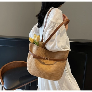 Détail du sac cabas en paille tissée avec bandoulière en cuir et boucle dorée élégante
