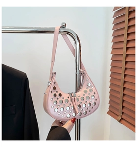 Détails des rivets métalliques argentés sur un sac seau rose en cuir poli brillant