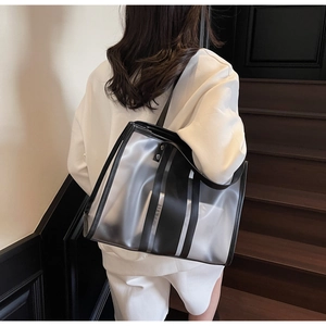 Sac fourre-tout transparent moderne à rayures noires porté à l'épaule en situation réelle