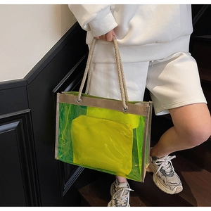 Detail of neon green transparent tote bag with rope handles and interior pouch on stairs
