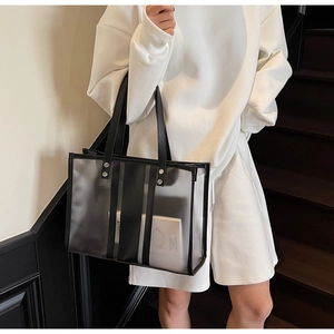 Vue détaillée d'un sac cabas transparent avec rayures noires et rivets métalliques