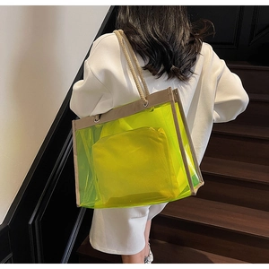 Neon green transparent PVC tote bag with canvas inner pouch shown on a model's shoulder
