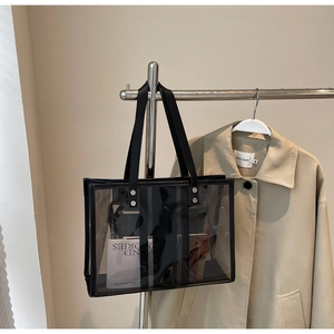 Gros plan du sac fourre-tout en PVC transparent avec poignées noires et rivets argentés
