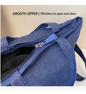Detailed close-up of smooth metal zipper and denim fabric texture on the tote bag