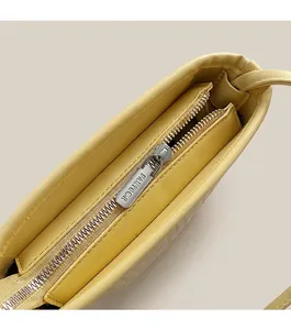 Gros plan détaillé de la fermeture éclair argentée sur un sac seau jaune gaufré