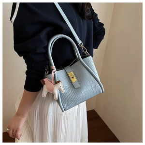 Borsa a mano celeste motivo coccodrillo con chiusura dorata e ciondolo pegaso