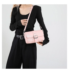 Détail du sac en cuir rose avec boucle argentée et bandoulière réglable pour femme