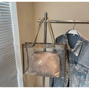 Detail of transparent PVC tote with beige inner pouch and braided rope handles