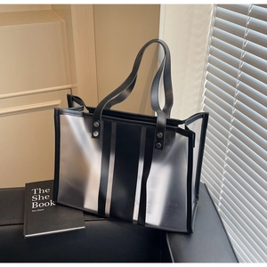 Détail du sac cabas transparent avec rayures noires et rivets métalliques renforcés