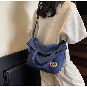 Detailed view of dark blue denim tote bag with cartoon flower embroidery and adjustable strap