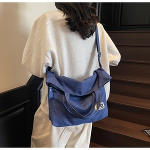 Detail of dark blue denim tote bag with cartoon patch on a vintage indoor wooden staircase