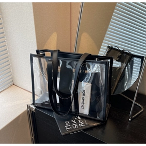 Détail d'un sac cabas transparent en PVC avec poignées en cuir noir et pochette interne