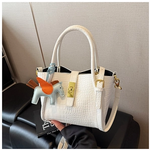Dettaglio borsa bianca a motivo coccodrillo con chiusura dorata e ciondolo pegaso