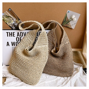 Detailed view of woven straw tote bags in beige and brown for summer beach styling