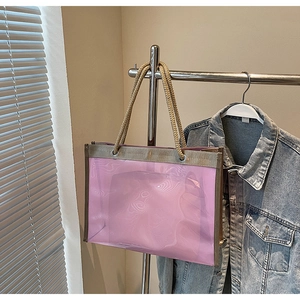 Detail view of purple transparent tote bag featuring woven rope handles and inner pouch