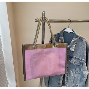 Detailed shot of pink translucent jelly tote bag with gold braided rope handles