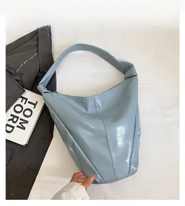 Détail du sac hobo bleu clair montrant le cuir verni brillant et les coutures verticales