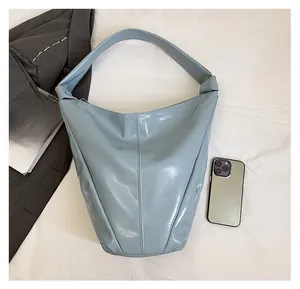 Sac hobo en cuir verni bleu clair avec large bandoulière et accessoires de mode modernes