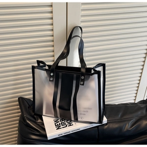 Détail du sac cabas noir transparent avec texture PVC mate et finitions en cuir