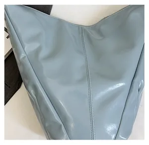 Détail du sac fourre-tout en cuir souple bleu clair montrant la texture et les coutures