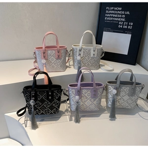 Detail of woven bucket bags in five colors with matching tassel charms and straps