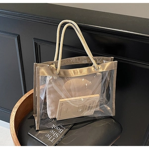 Detail of transparent PVC tote bag with thick woven handles and beige inner pouch