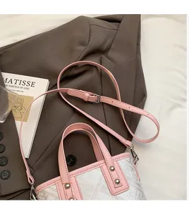 Detail of the pink leather handles and woven fabric texture of the stylish bucket bag