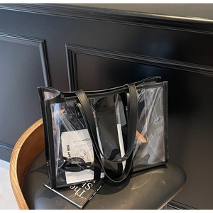 Détail du sac cabas transparent en PVC avec bordures noires posé sur une chaise