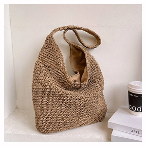 Detailed close-up of handmade straw woven tote bag showing tight weave and warm khaki texture