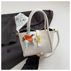Dettaglio borsa a secchiello bianca a coccodrillo con chiusura oro e charm pegaso