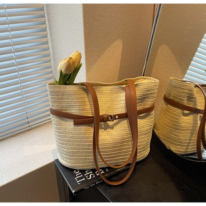Détail d'un sac cabas tissé beige avec lanières en cuir marron et boucle élégante