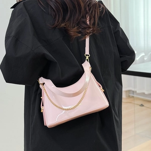 Close-up of pink patent leather bucket bag with gold chain and Forever Young lettering