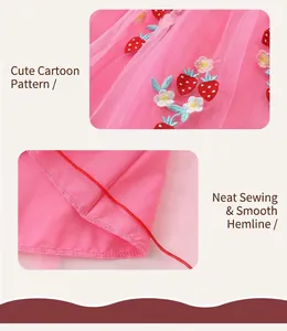 Détail de broderie fraise sur tulle rose et coutures fines de la robe pour fille