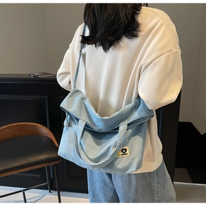 Detailed view of light blue canvas tote bag featuring a cute cartoon bear patch