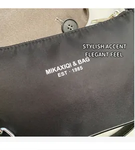 Macro detail of black nylon bag showing white logo print and silver metal zipper