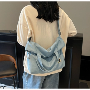 Detail of light blue vintage canvas tote bag with adjustable strap and heart patch