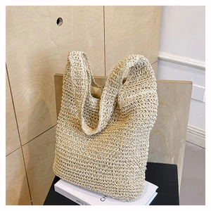 Close-up of beige crochet tote bag with hollow woven texture and integrated shoulder strap