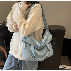 Detailed view of light blue denim canvas tote bag with adjustable shoulder strap and handle