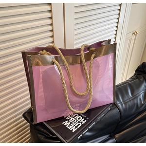 Detailed view of pink transparent PVC tote bag with woven handles and inner pouch