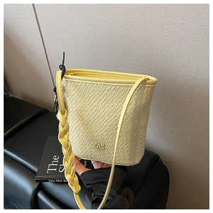 Détail du sac seau jaune à texture crocodile et logo de la marque PAN TOR sur la base