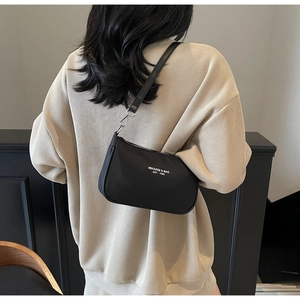 Detailed back view of a black minimalist shoulder bag with logo showing real-life proportions